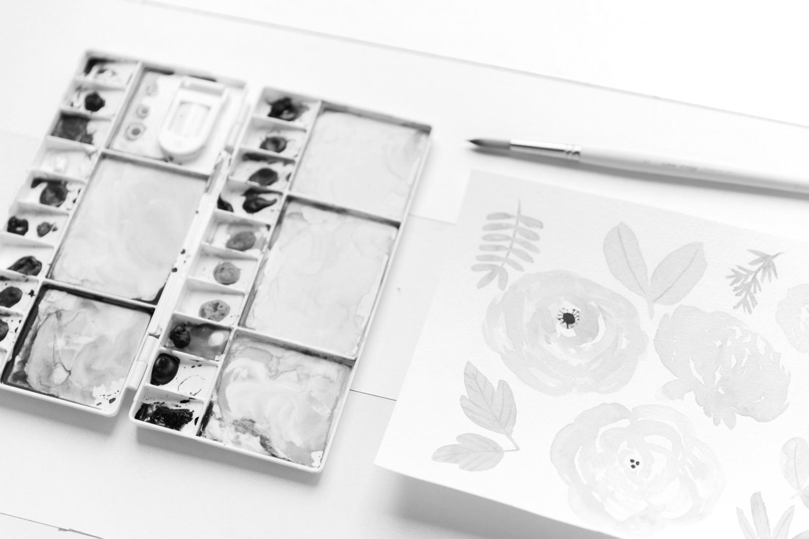 Verschiedene Zeichenstifte und Materialien arrangiert auf hellem Untergrund